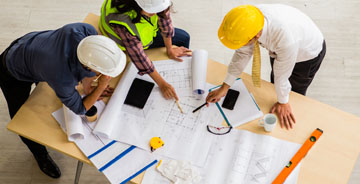 Aerial view of electrical technicians reviewing design plans